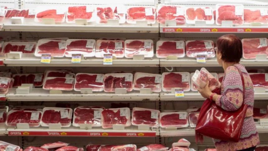 Consumidora escolhendo carne na gôndola