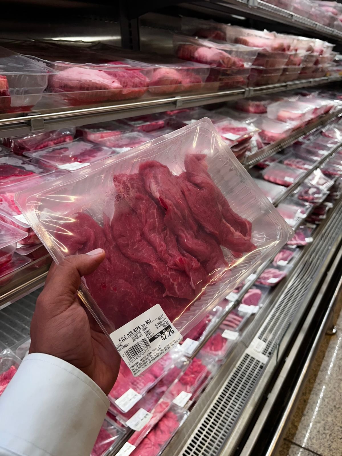 Bandeja transparente de carne na mão