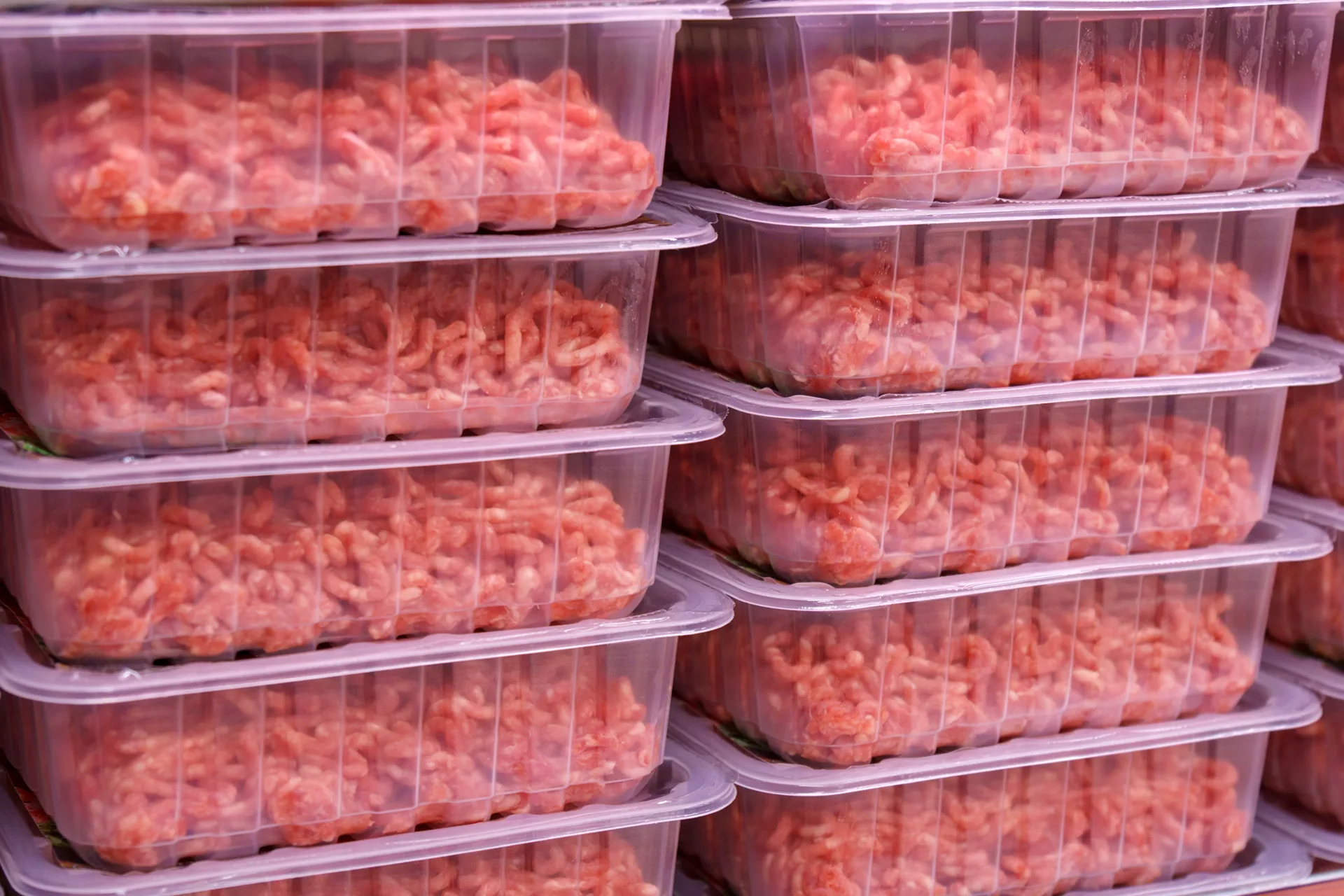Diversas bandejas de carne moída embaladas e empilhadas